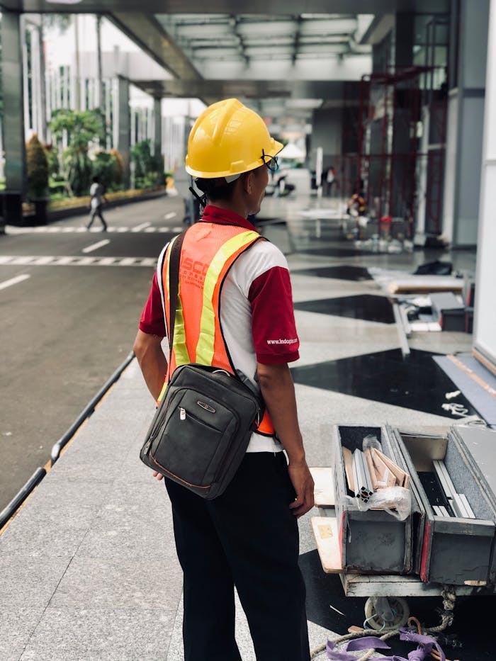services-03 Construction worker standing on Jakarta street, wearing safety gear and helmet.